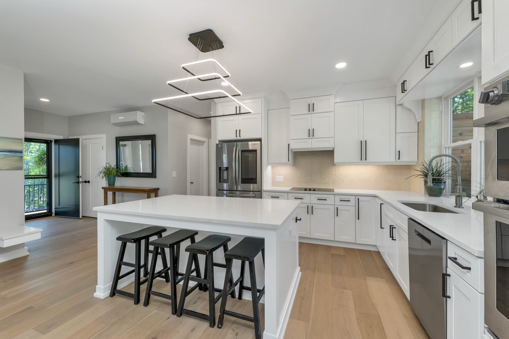 Gourmet white kitchen with a large quartz island and bar seating