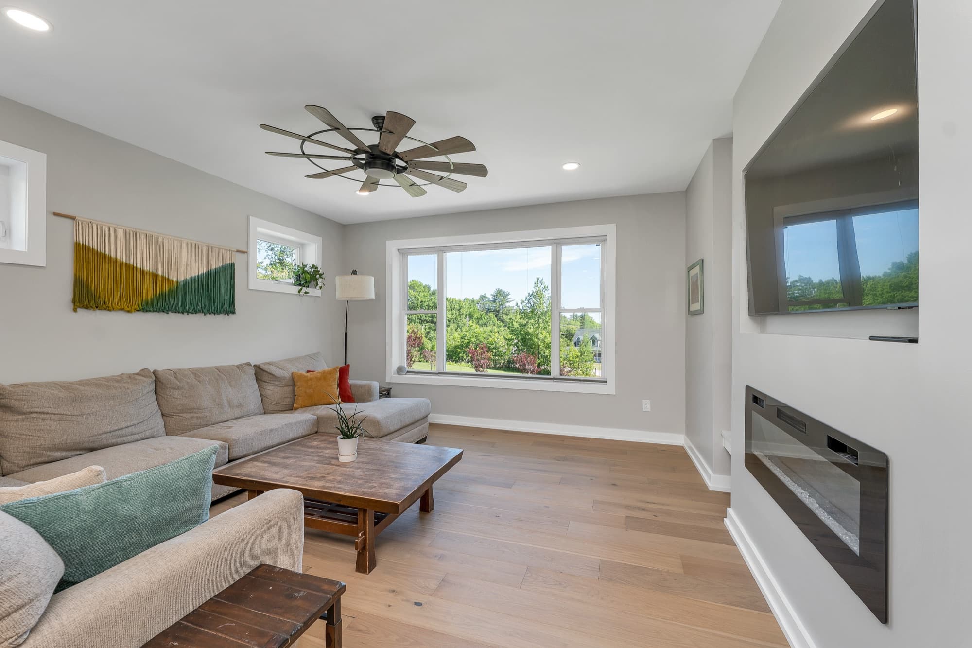 Living room with a linear fireplace and wide-plank floors