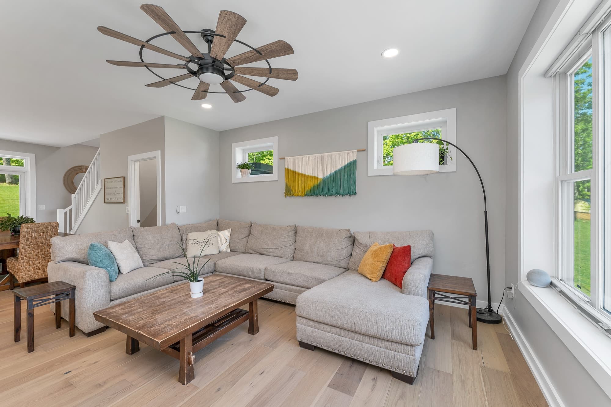 Sun-filled great room with a sectional and statement ceiling fan