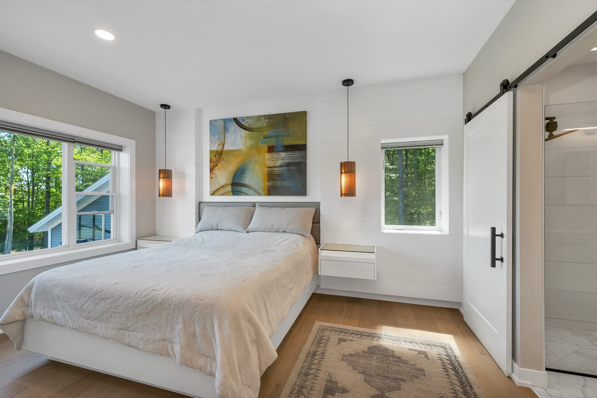 Primary bedroom with pendant lighting and a sliding barn door