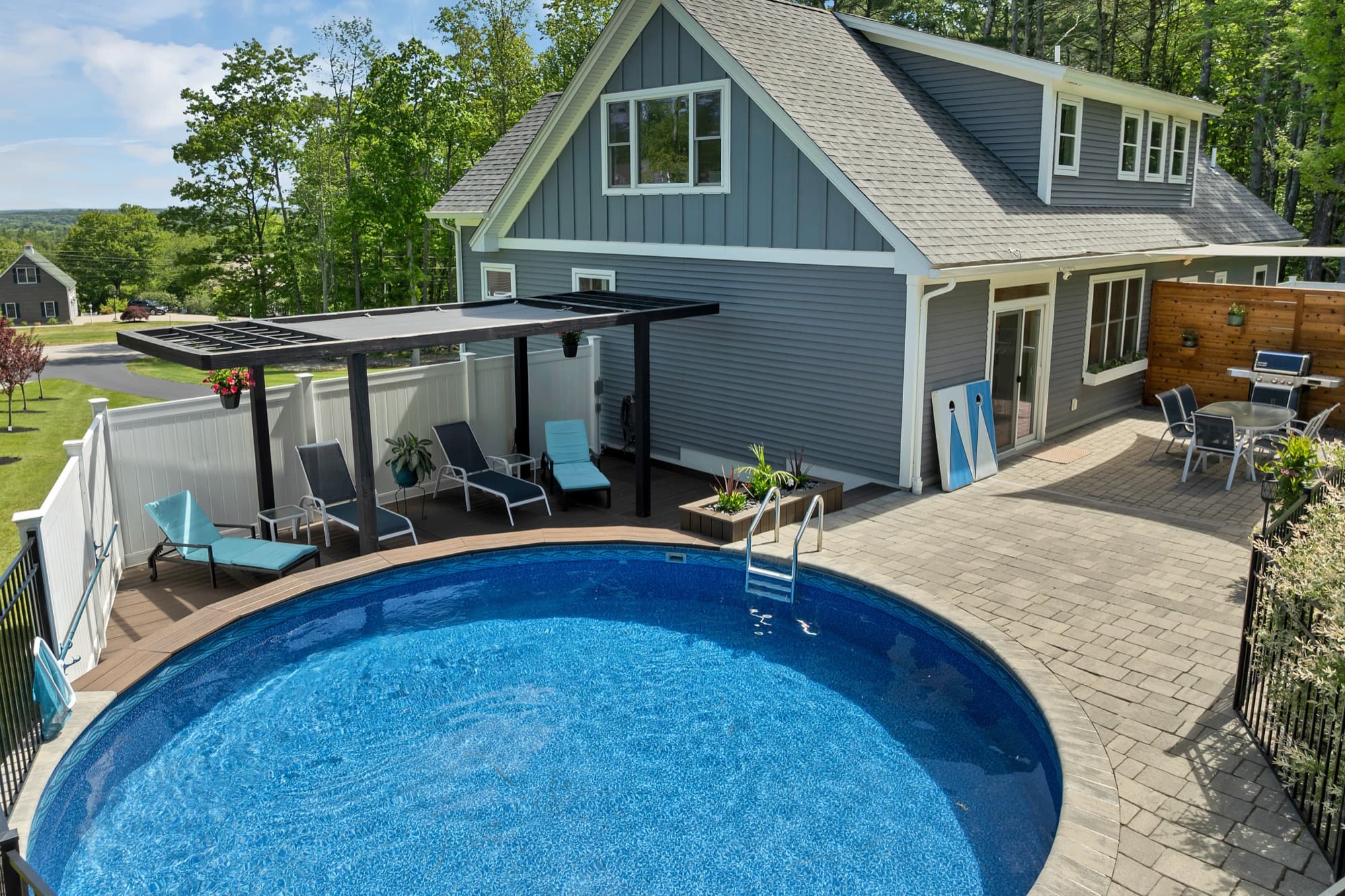 Pool with a custom paver patio and pergola-shaded deck