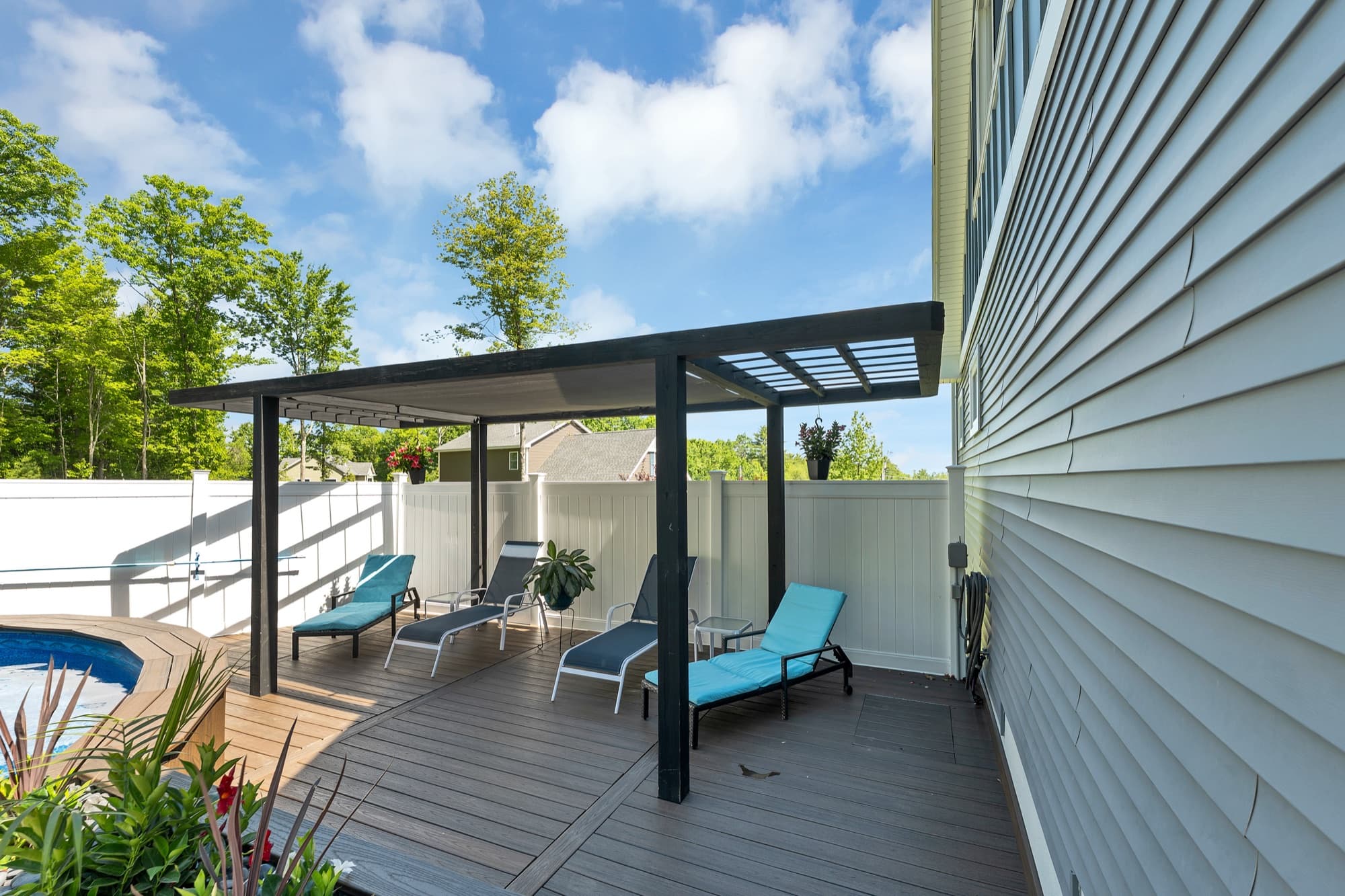 Covered pergola porch with lounge seating overlooking the pool